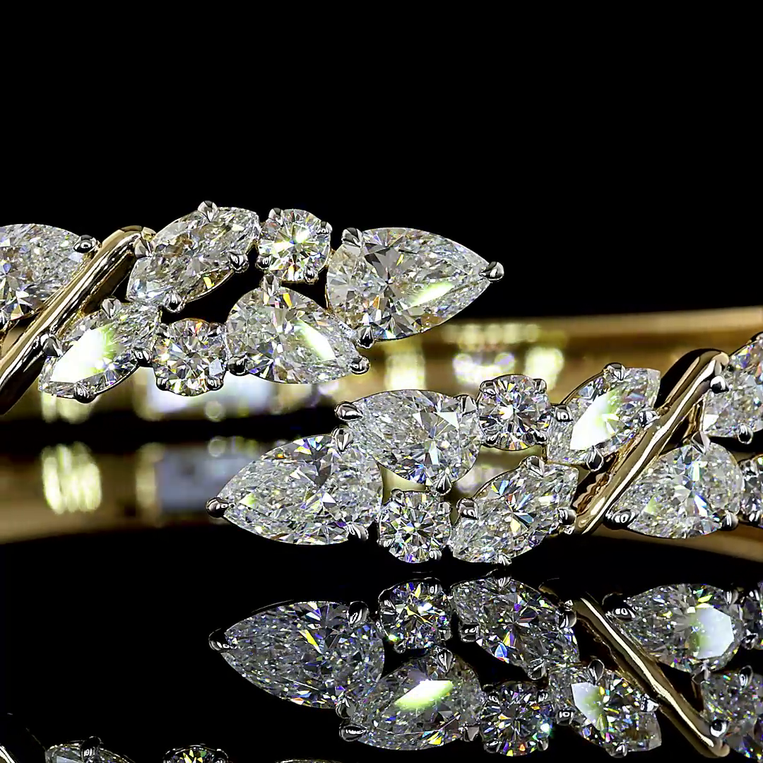 Close-up of a 14k yellow gold hinged cuff featuring 8.09ctw of mixed shape lab grown diamonds.
