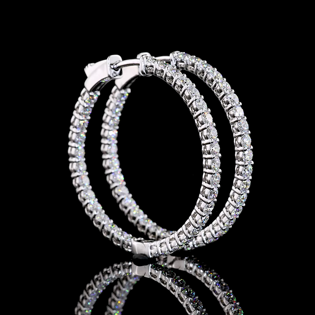 A pair of 14k white gold hoop earrings set with 5.12 carats of lab grown round diamonds.
