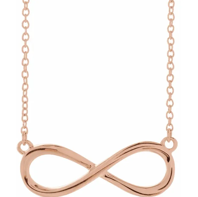 Rose gold infinity necklace on a white background.