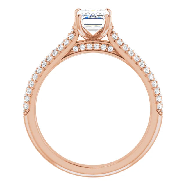 Emerald cut diamond ring with pavé set diamonds on a rose gold band.