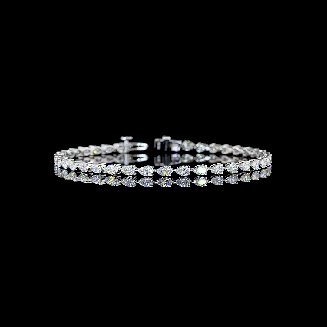 3.98ctw lab grown pear cut diamond tennis bracelet in 14k white gold on a black background.