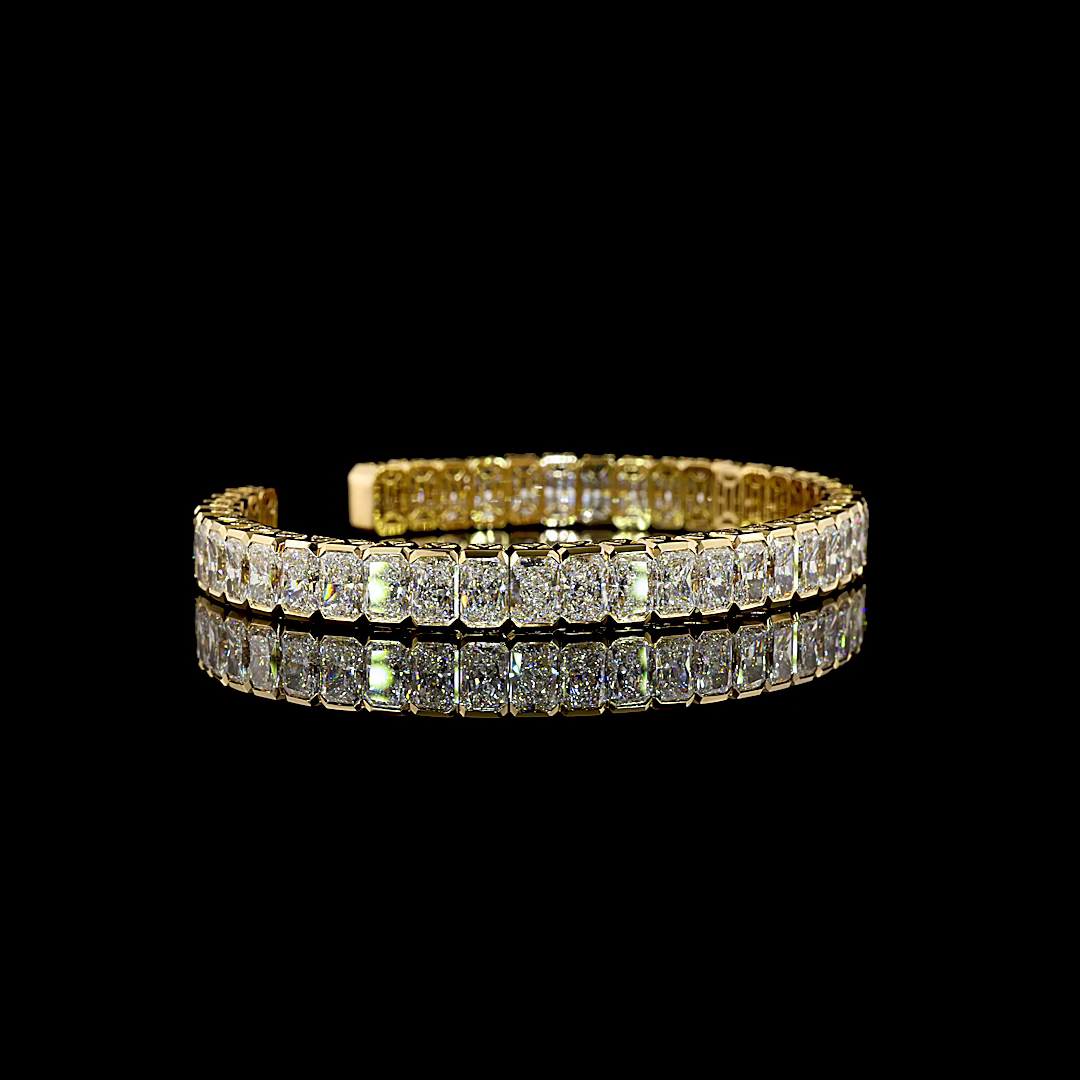 26.37ctw lab grown radiant cut diamond cuff bracelet in 14k yellow gold on a black background.