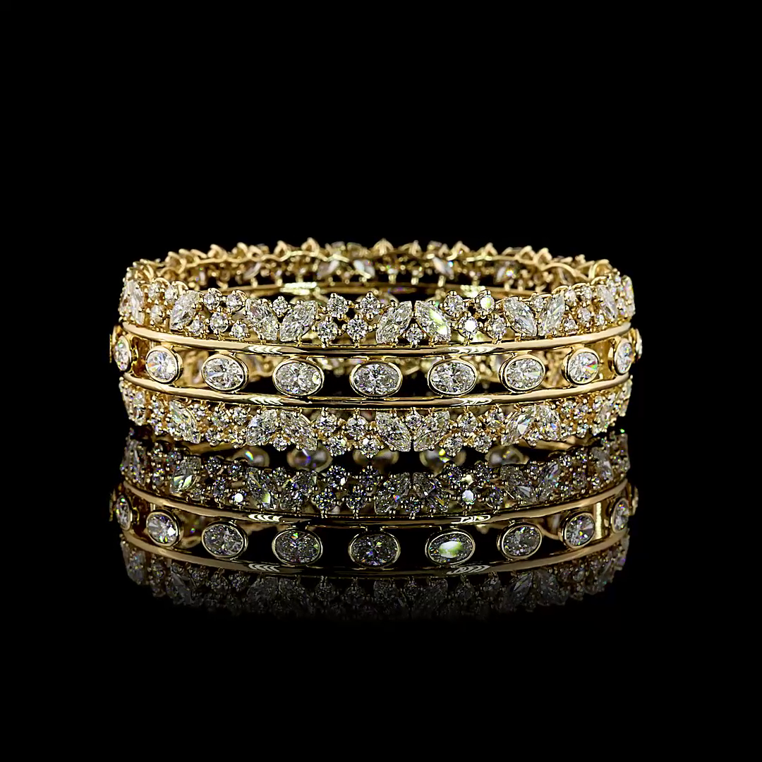 14k yellow gold hinged bangle featuring 19.26ctw of oval and mixed cut lab grown diamonds.