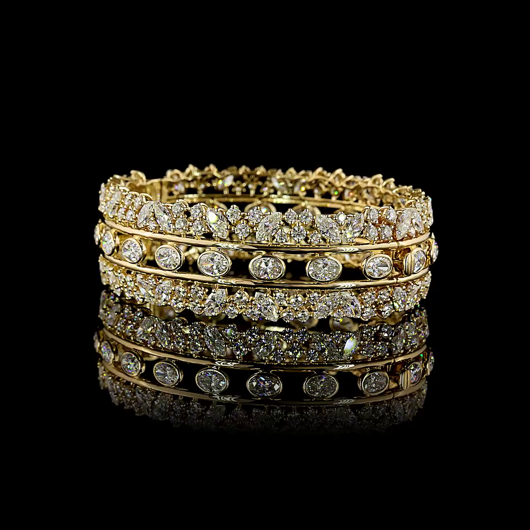 14k yellow gold hinged bangle with 19.26ctw lab grown oval and mixed-cut diamonds.