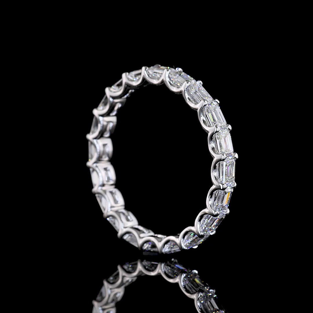 Lab grown emerald cut diamond eternity band in 14k white gold on a black background.