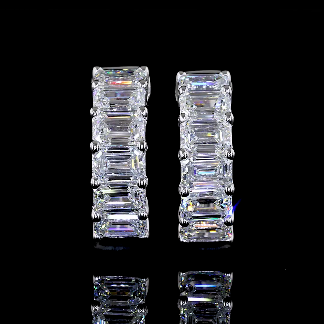 1.98ctw lab grown emerald cut diamond huggie earrings in 14k white gold on a black background.