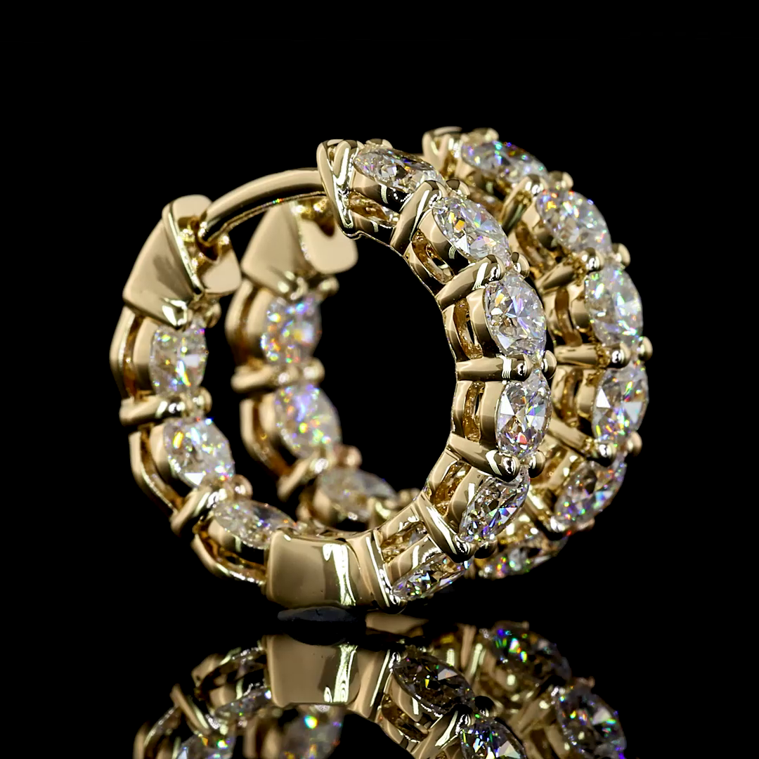 A pair of 14k yellow gold huggie earrings set with 1.93 carats of round lab grown diamonds.