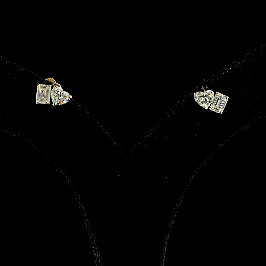 1.56ctw lab grown heart and emerald cut diamond stud earrings in 14k yellow gold.