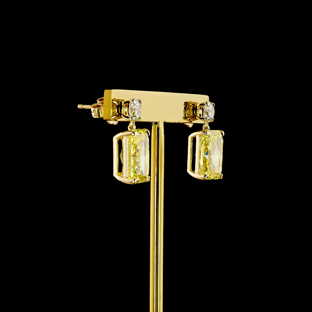14k yellow gold earrings with round white and large radiant-cut fancy vivid yellow lab diamonds.