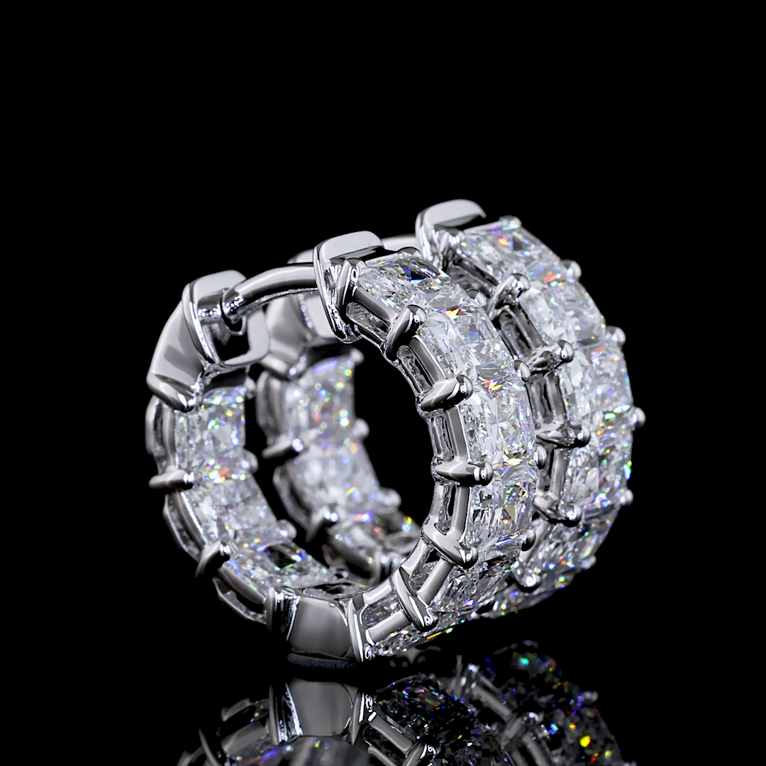 A pair of 14k white gold huggie earrings set with radiant-cut lab grown diamonds on a black surface.