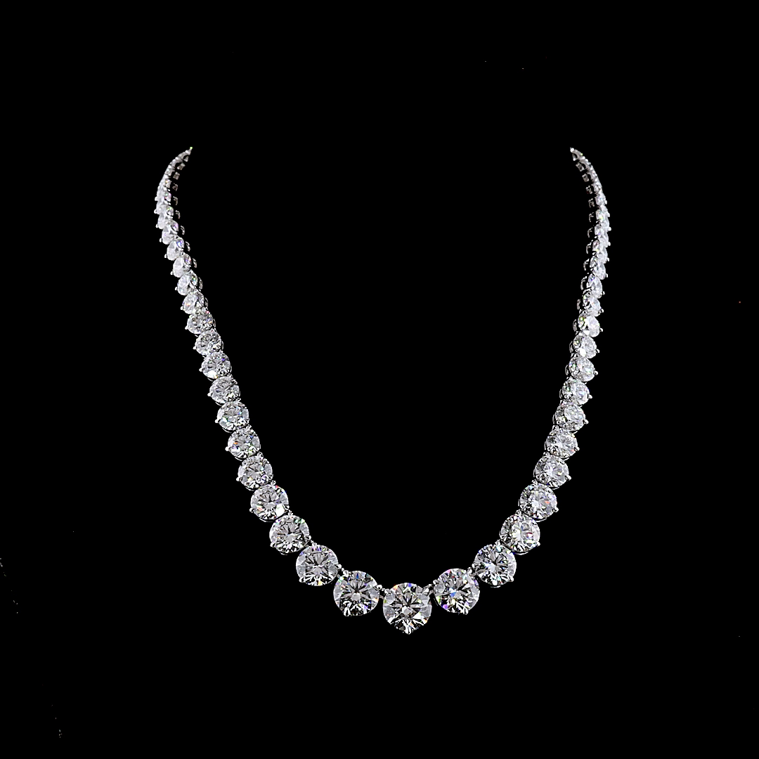 Graduated lab grown diamond riviera necklace in 14k white gold on a black background.