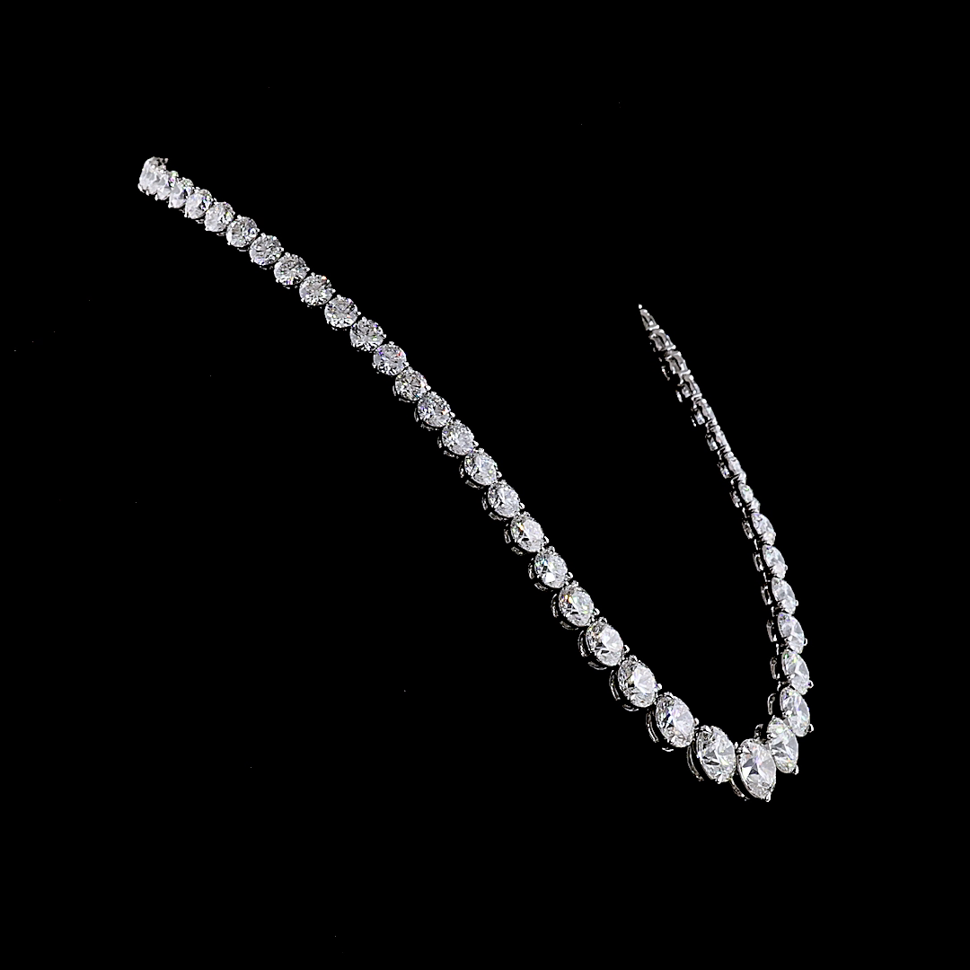 Graduated round cut lab grown diamond Riviera necklace in 14k white gold on a black background.