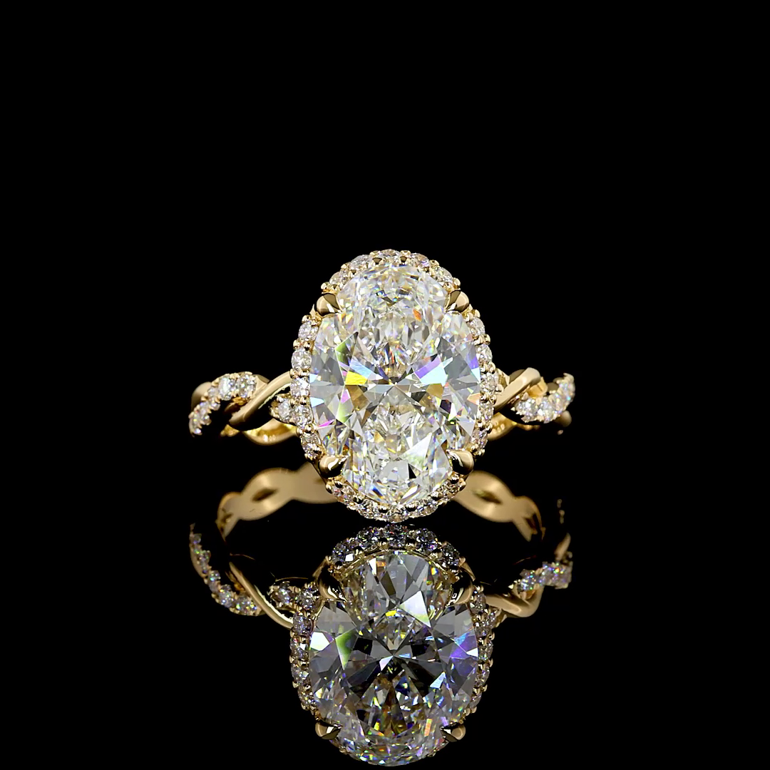 3.55ctw lab grown oval diamond engagement ring in 18k yellow gold with halo and twisted pavé band.