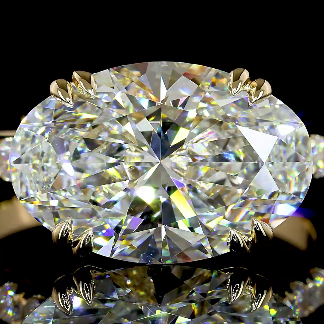 Close-up of a 4.89ctw oval lab grown diamond engagement ring in a 14k yellow gold prong setting.
