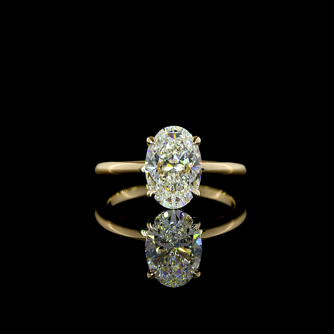 2.12ct lab grown oval diamond solitaire engagement ring in 14k yellow gold on a black background.