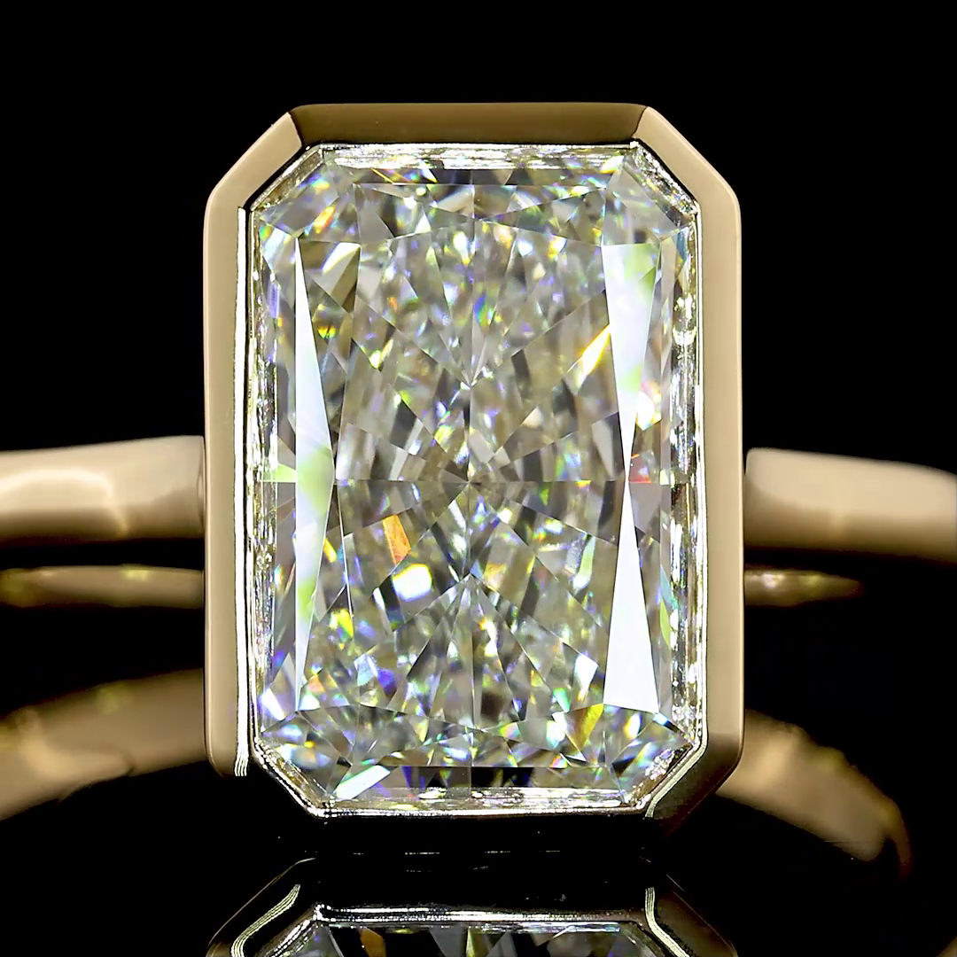 Close-up of a 3.17ct radiant cut lab grown diamond in a 14k yellow gold bezel setting.