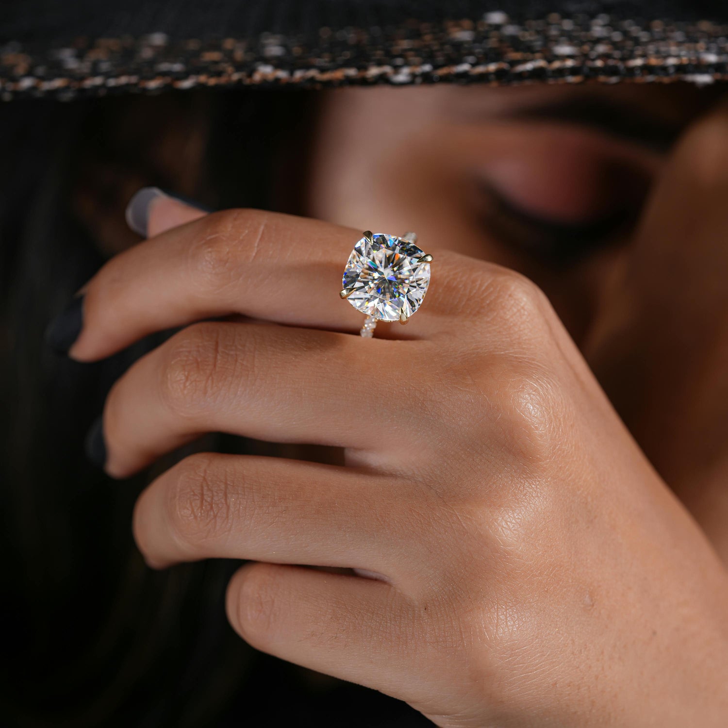 Close-up of a hand wearing a diamond ring with a blurred background