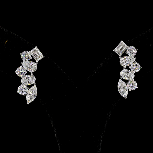 14k white gold ear climber earrings rotating in a 360 video on black background. Set with lab grown diamonds in round, oval, pear, marquise, and emerald cuts.