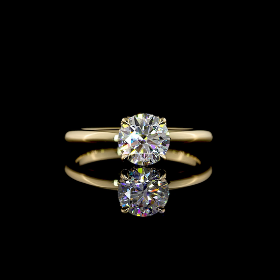 A 14k yellow gold engagement ring, set with a 1.08ct round cut lab grown diamond, surrounded by a thin hidden halo, on a plain band. The ring is rotating 360 degrees on a black background.