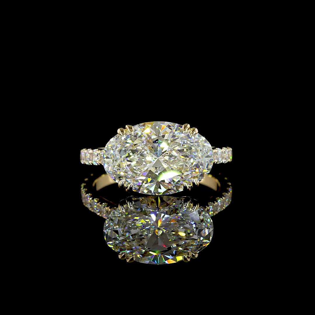 A yellow gold lab grown diamond engagement ring rotating on a black background. It is set with a 4.26ct oval cut lab grown diamond with double cat claws in an east-west (horizontal) orientation. The band is a cathedral design with lab grown diamonds extending halfway around the ring.