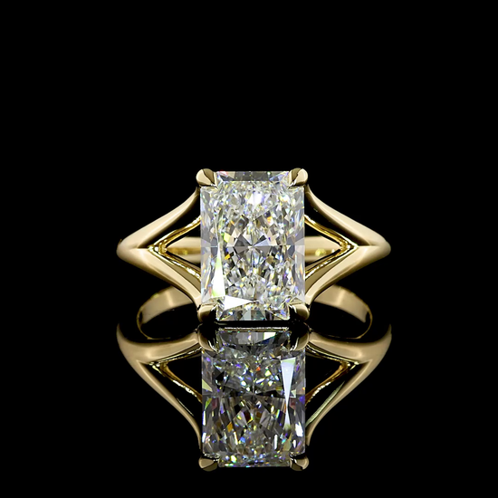 A 360 rotating video of a 14k yellow gold solitaire split shank design engagement ring set with a 3.12ct lab grown radiant cut diamond, on a black background.