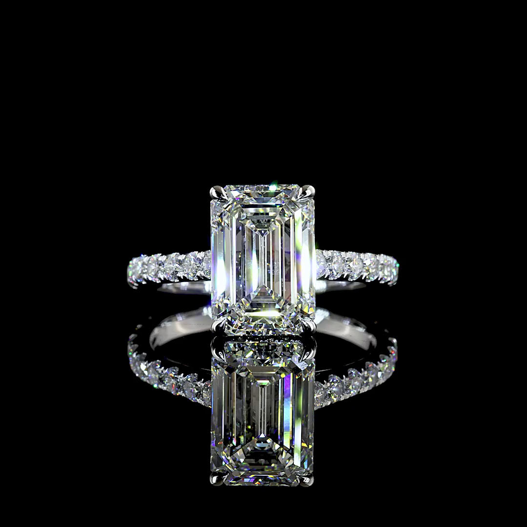A white gold lab grown diamond engagement ring rotating on a black background. It is set with a 3.19ct emerald cut centre lab diamond, with a hidden halo and lab diamonds halfway down the band.