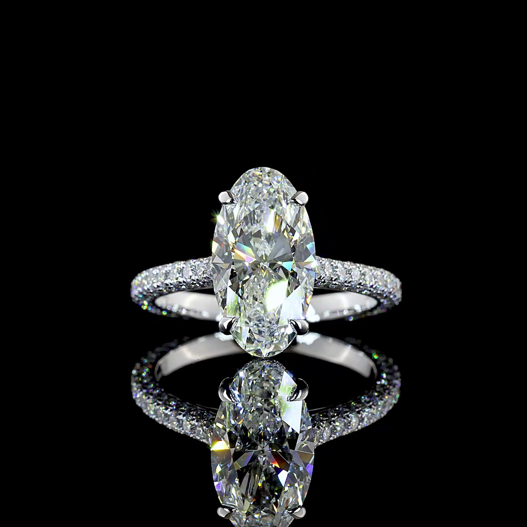 A 360 rotating video of a 14k white gold engagement ring on a black background. The ring is set with a 2.66ct moval cut lab grown diamond, with a hidden halo and a three sided pave diamond band.