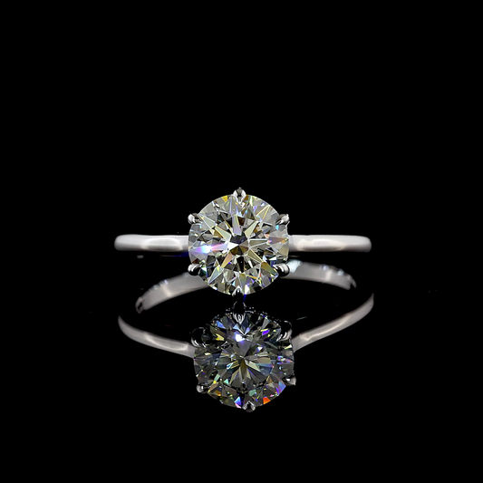 A 14k white gold engagement ring rotating on a black background. It is 6 prong set with a 1.50ct round cut lab grown diamond, surrounded by a hidden halo of lab grown diamonds set with cathedral shoulders on a thin band. 